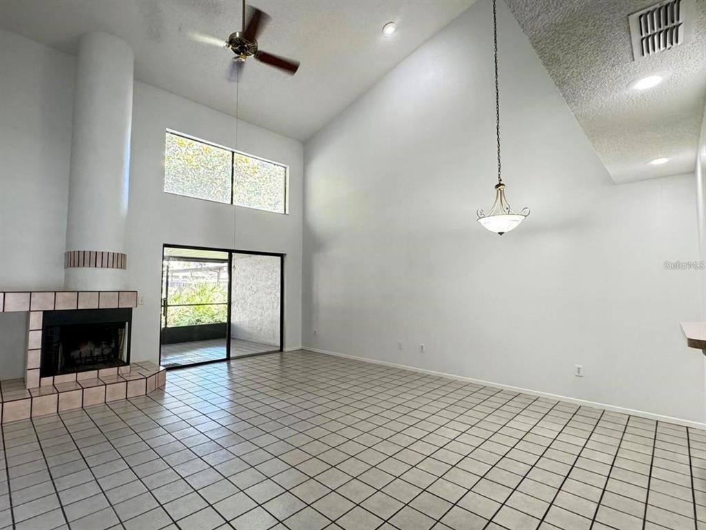 A living room with high ceilings, a tiled fireplace, and white tile flooring — 497 CLUB DRIVE, WINTER SPRINGS, FL