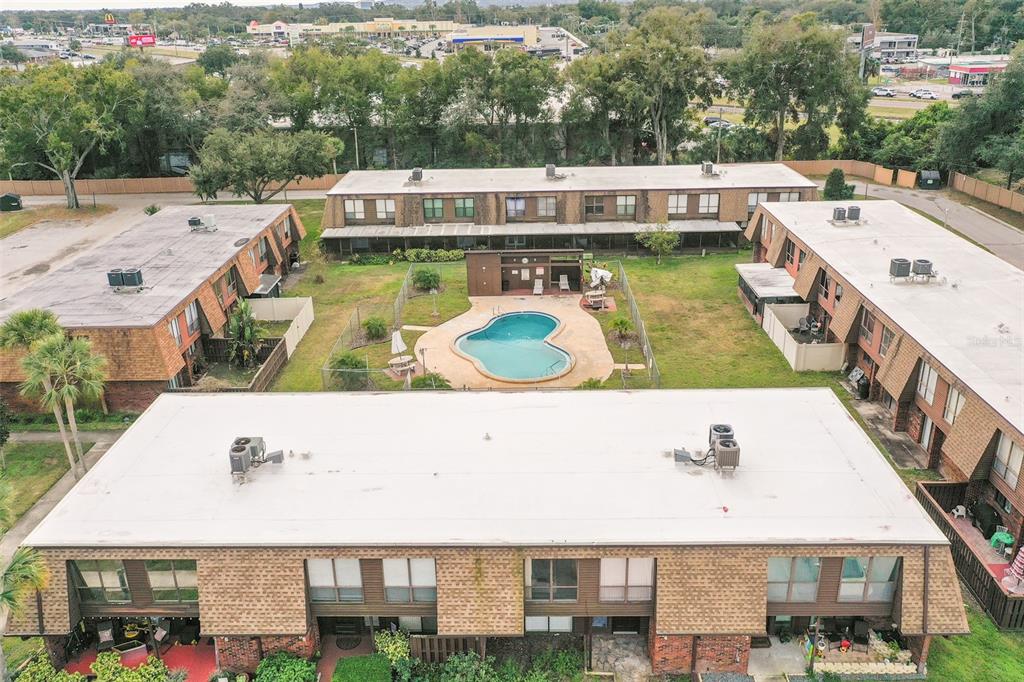 An aerial view shows a multi-unit apartment complex surrounding a central courtyard with a pool — 1836 N CRYSTAL LAKE DRIVE UNIT 104, LAKELAND, FL