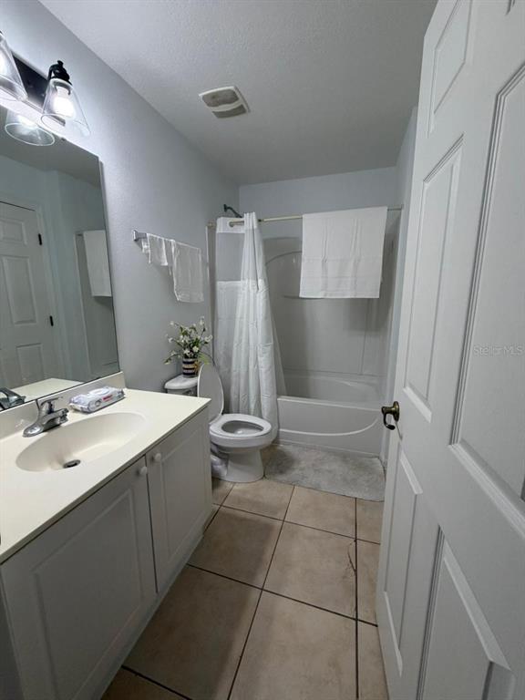 A bathroom features a vanity with a sink, a toilet, and a shower-tub combination — 2714 CLUB CORTILE CIRCLE, KISSIMMEE, FL