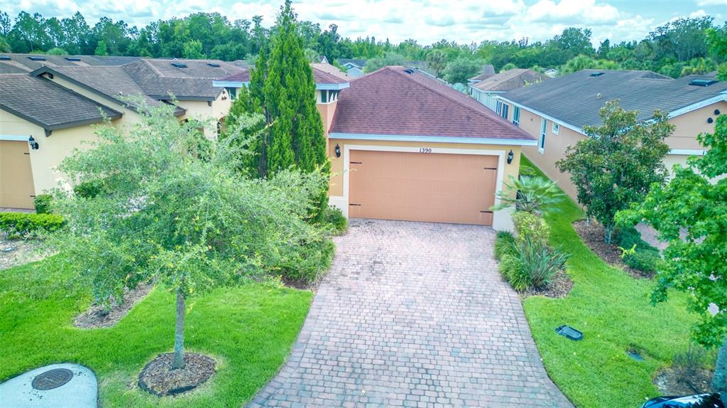 An aerial view of a suburban house with a brick driveway and a two-car garage — 1390 HARBOR RIDGE DRIVE, KISSIMMEE, FL
