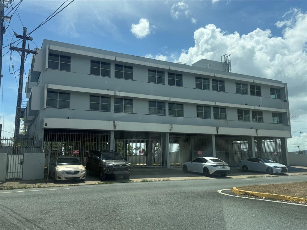 A three-story gray commercial building with a ground-level parking garage and gated entrance — 174 DR. AGUSTIN STAHL, BAYAMON, PR