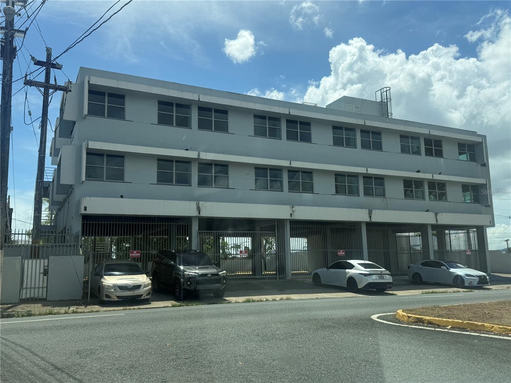 A three-story gray commercial building with a ground-level parking garage and metal security gates — 174 DR. AGUSTIN STAHL, BAYAMON, PR