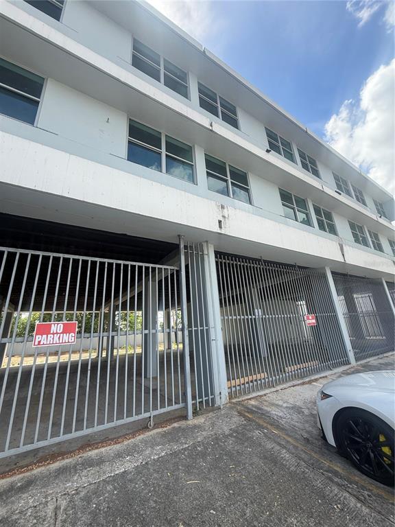 A low-angle view of a multi-story building with a gated ground-level parking area — 174 DR. AGUSTIN STAHL, BAYAMON, PR