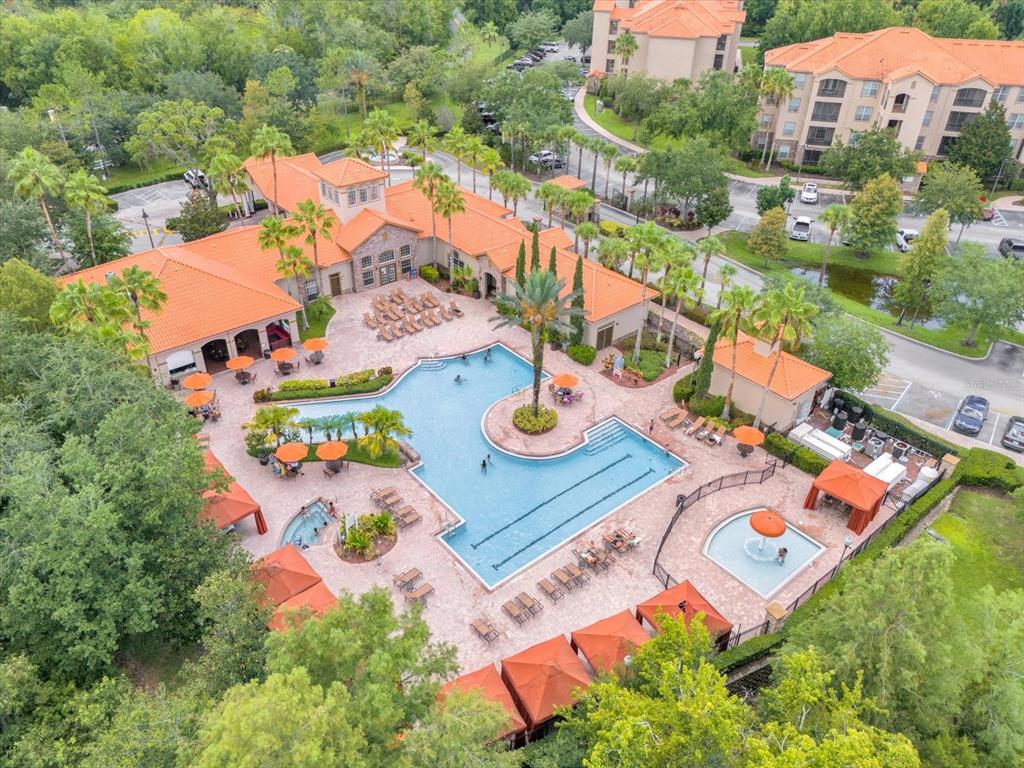 An aerial view of a resort-style swimming pool complex with lounge chairs and cabanas — 1351 TUSCAN TERRACE UNIT 8101, DAVENPORT, FL