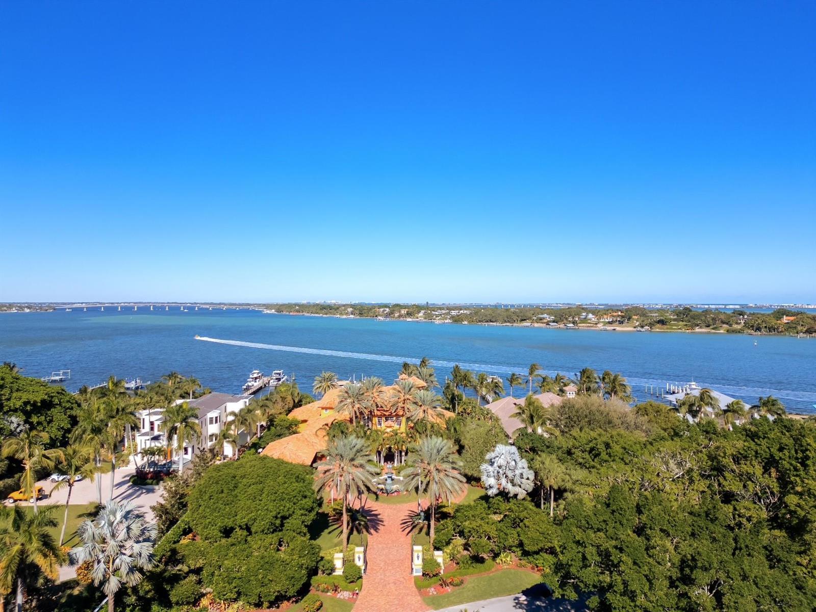 An aerial view of a waterfront estate with a brick driveway and lush tropical landscaping — 4089 SE Old Saint Lucie Boulevard, Stuart FL 34996, STUART, FL