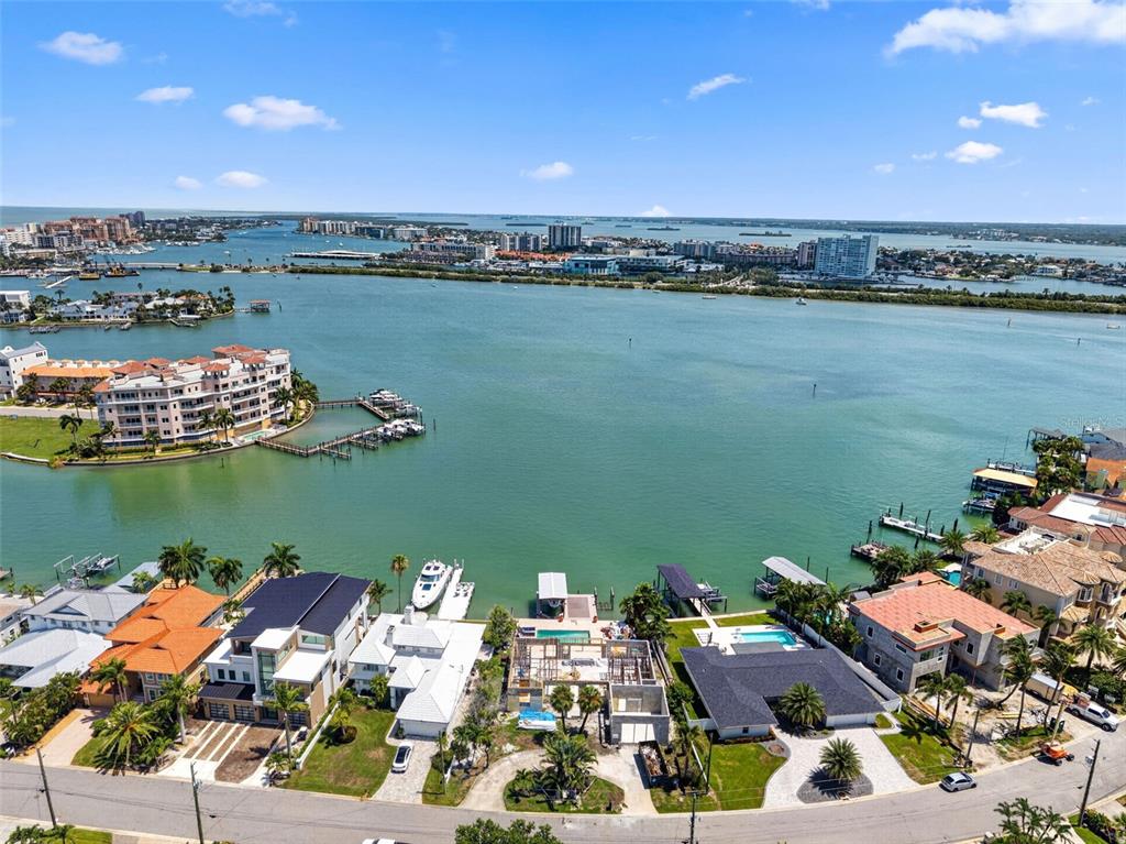 An aerial view shows waterfront homes along a bay with docks and boats — 246 BAYSIDE DRIVE, CLEARWATER BEACH, FL