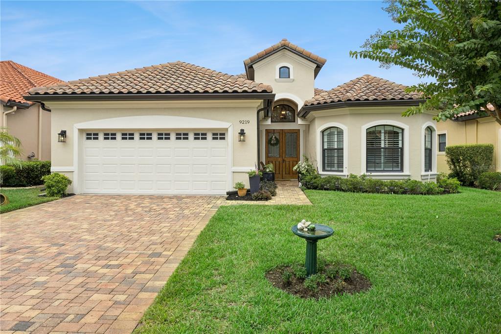 A single-story house with a tiled roof, a two-car garage, and a paved driveway — 9219 SAN JOSE BOULEVARD, HOWEY IN THE HILLS, FL
