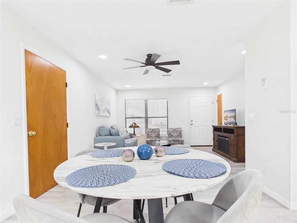 A dining area with a round marble table sits in front of a living room — 7686 SW 81ST STREET, OCALA, FL