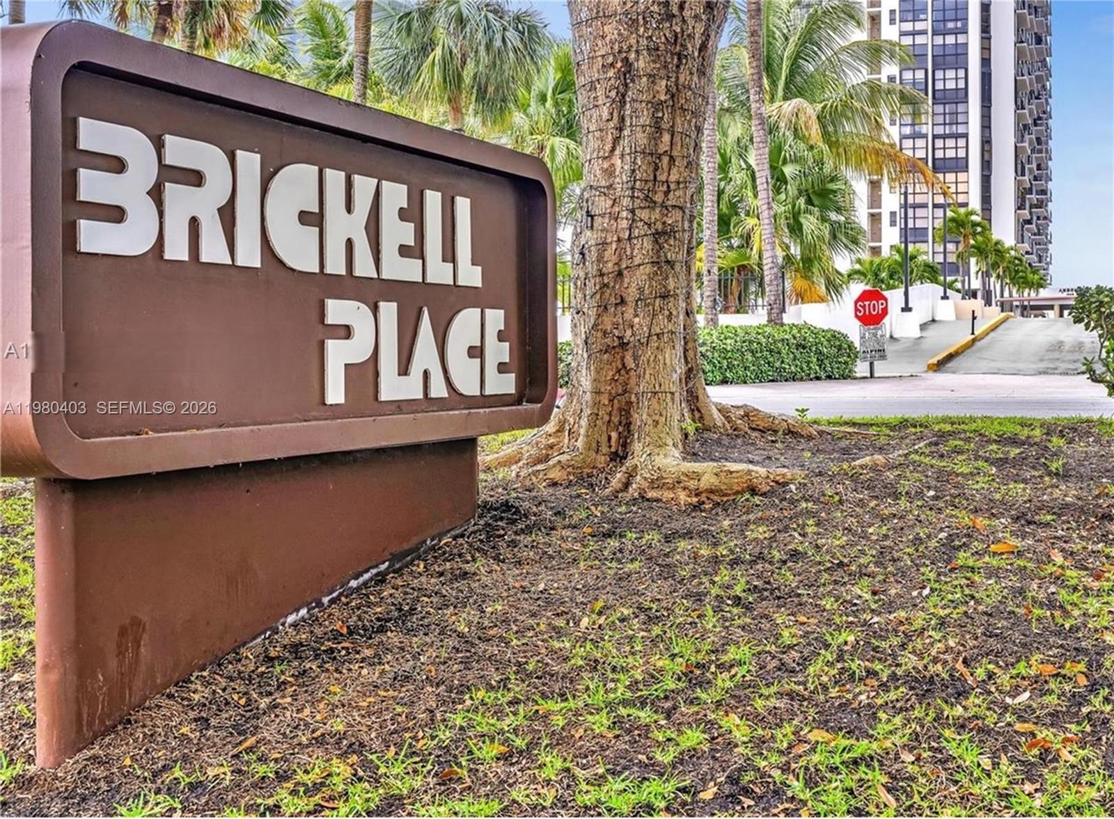 A brown Brickell Place sign stands in front of a tree and a tall building — 1901 Brickell Ave # B1407, Miami FL 33129, MIAMI, FL