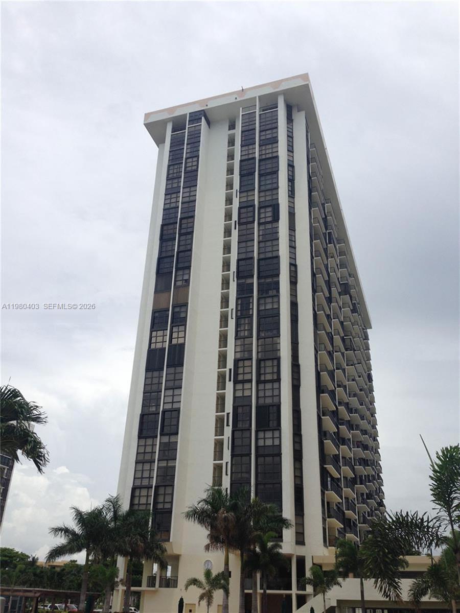A tall, white residential high-rise building features a grid of dark windows and stacked balconies — 1901 Brickell Ave # B1407, Miami FL 33129, MIAMI, FL