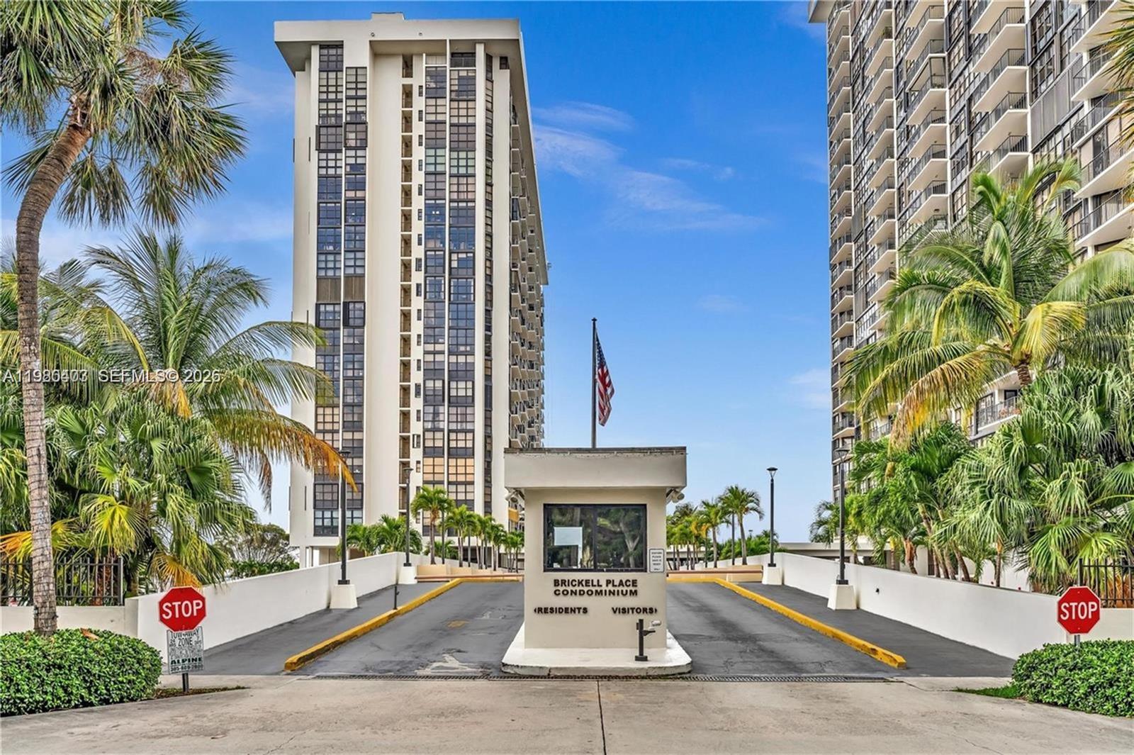 The entrance to a condominium complex features a guard booth between two driveways with stop signs — 1901 Brickell Ave # B1407, Miami FL 33129, MIAMI, FL