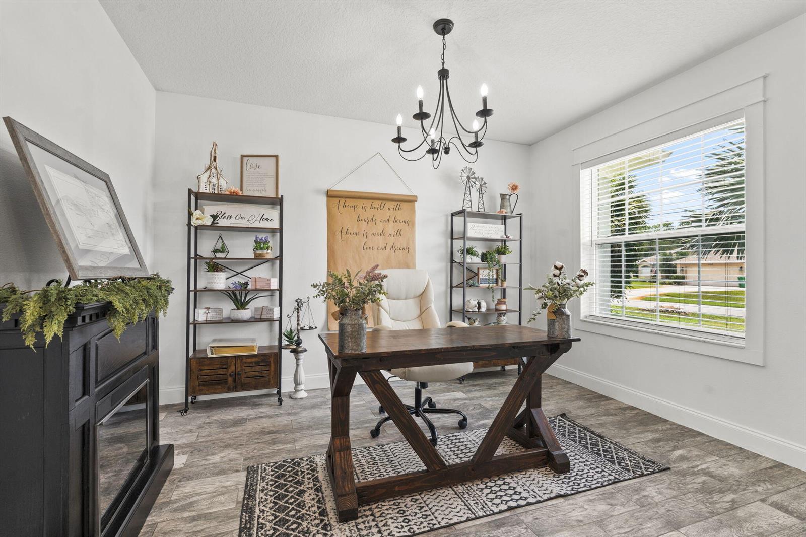 A home office features a wooden desk, two metal shelves, and a black chandelier — 2141 SW Leafy Road, FL 34953, FL