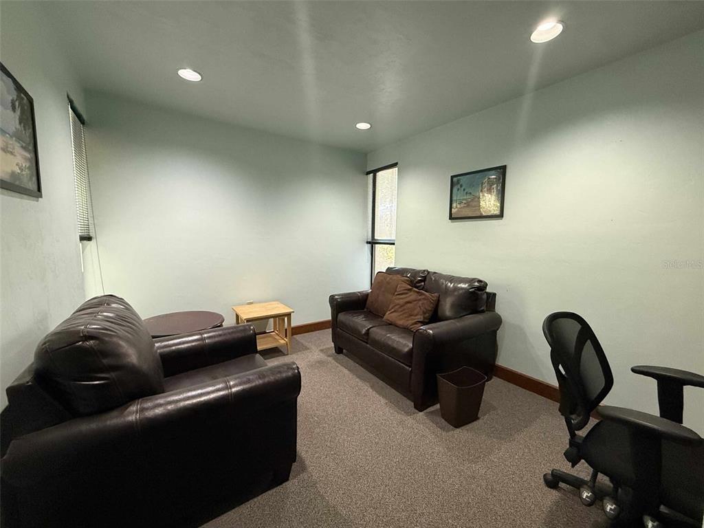 A room with two dark leather sofas, a small wooden table, and an office chair — 2833 NW 41ST STREET UNIT 140 Room C, GAINESVILLE, FL