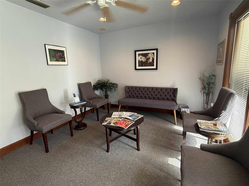 A waiting room features gray upholstered chairs, a tufted settee, and a central coffee table — 2833 NW 41ST STREET UNIT 140 Room C, GAINESVILLE, FL