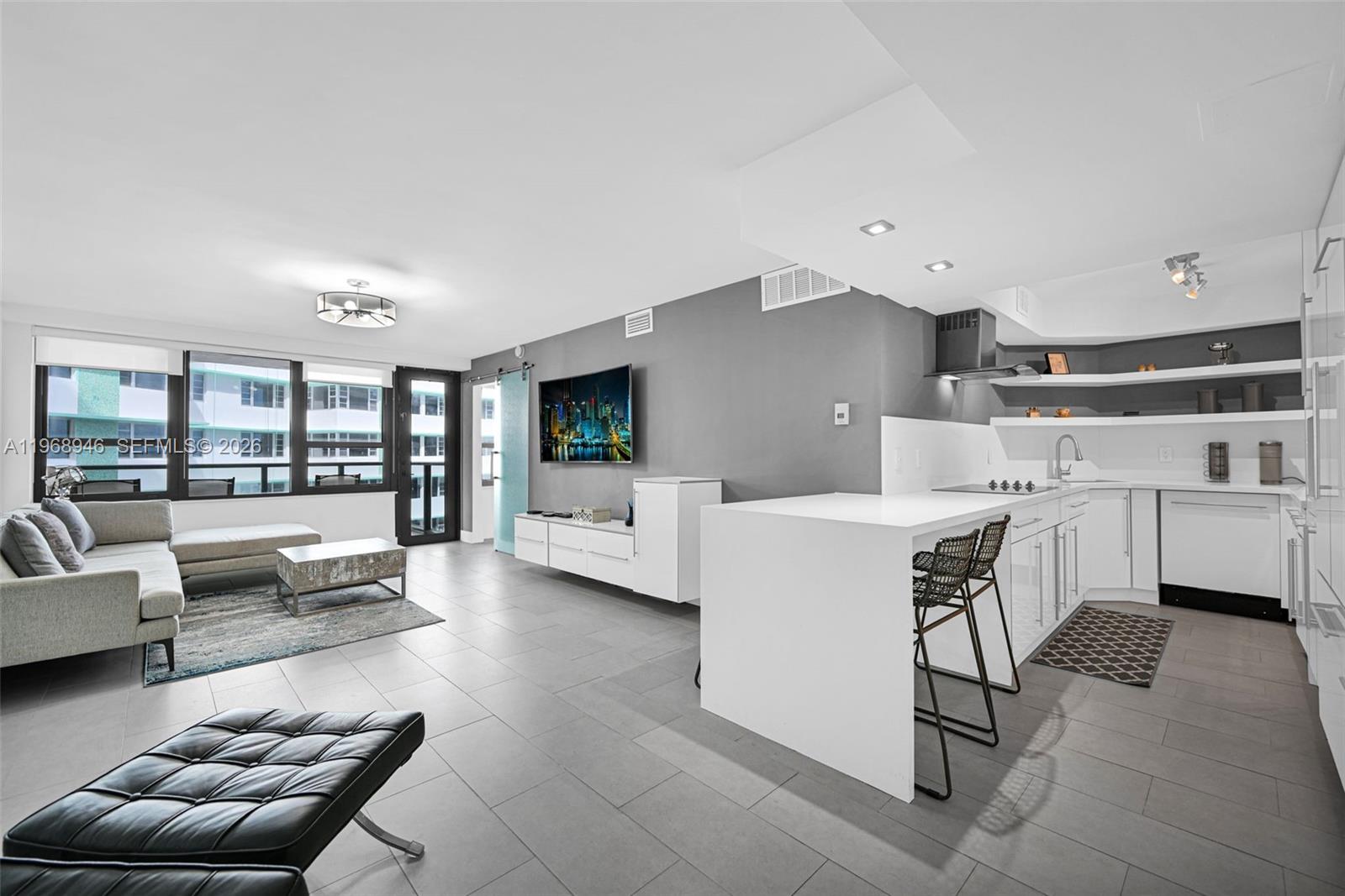 An elevated view of a resort swimming pool with a tiki bar and beach access — 5225 Collins Ave # 714, Miami Beach FL 33140, MIAMI BEACH, FL