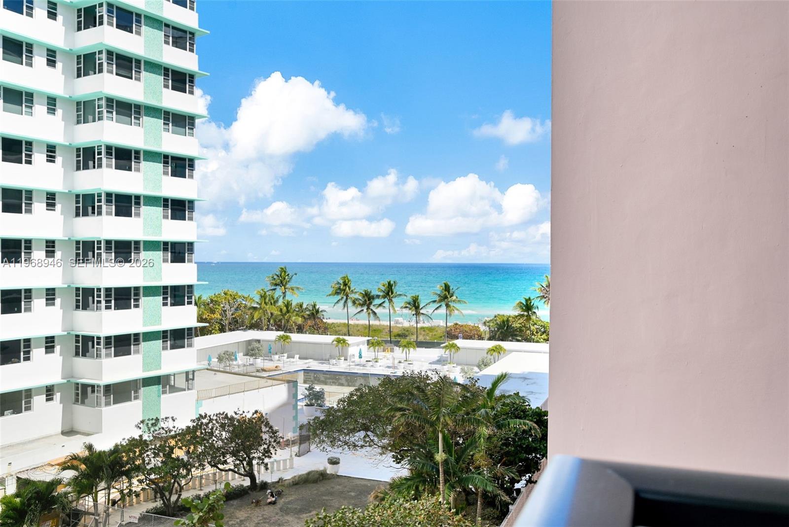 A modern open-concept living room and kitchen feature gray tile floors and white cabinetry — 5225 Collins Ave # 714, Miami Beach FL 33140, MIAMI BEACH, FL