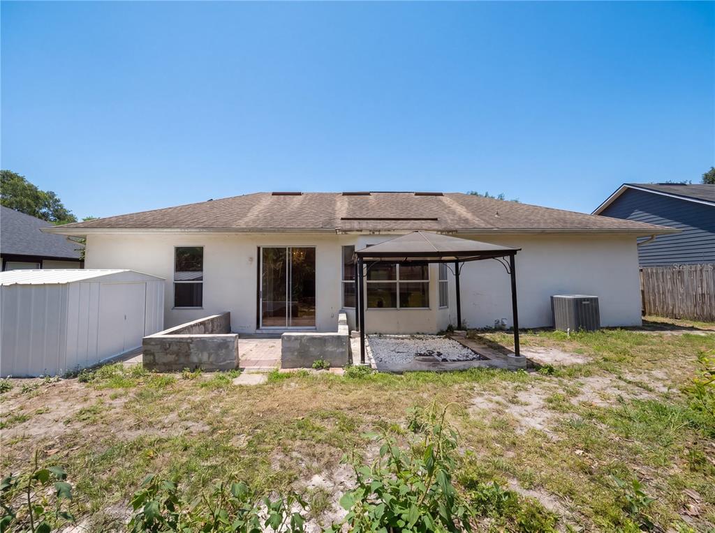 The backyard of a house features a patio, a gazebo, and a storage shed — 5263 CLARION OAKS DRIVE, ORLANDO, FL