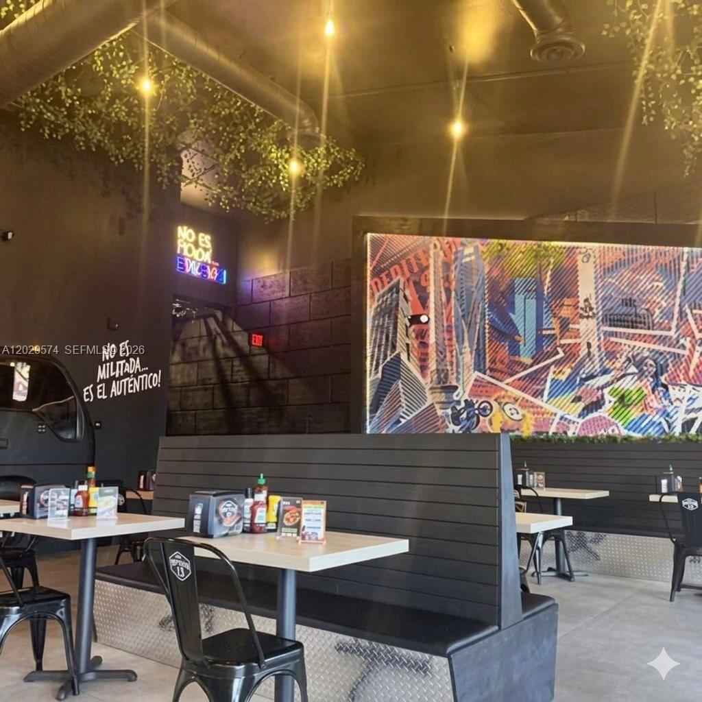 A restaurant interior features black booths, light-colored tables, and a large colorful mural on the wall — 8205 NW 12th St, Doral FL 33126, DORAL, FL