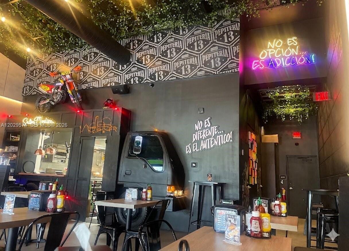 The interior of a restaurant features a motorcycle, a truck front, and neon wall signage — 8205 NW 12th St, Doral FL 33126, DORAL, FL