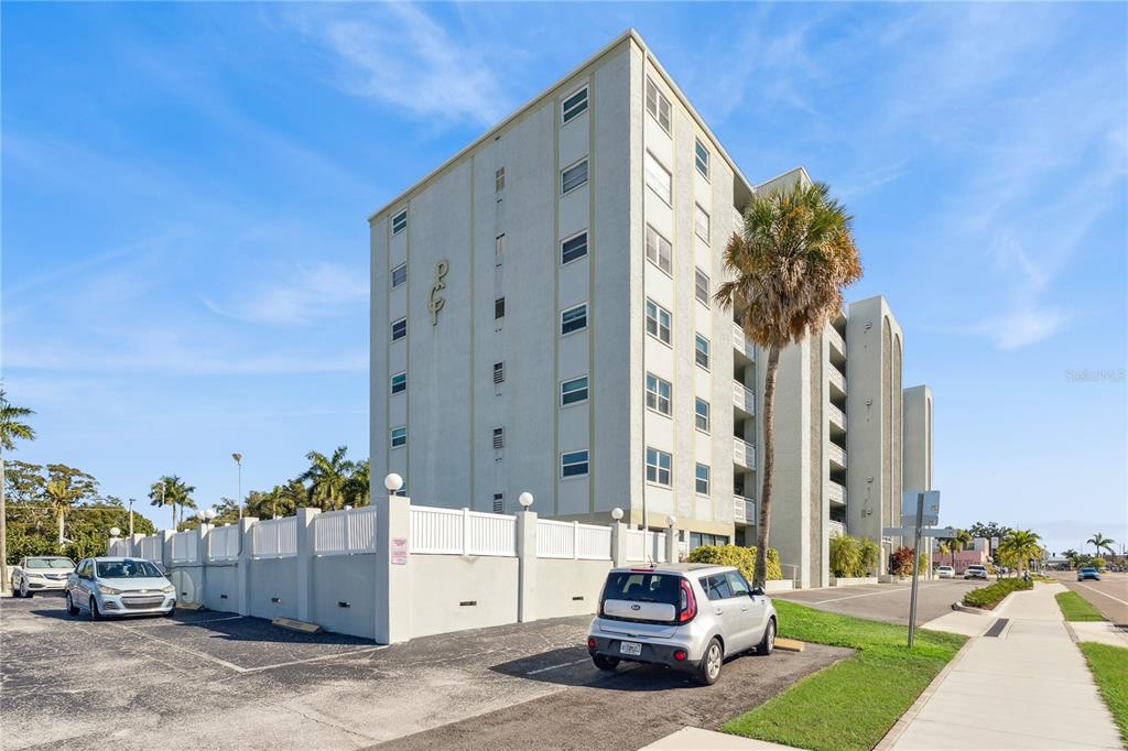 A multi-story apartment building with a parking lot and a palm tree in front — 7321 CENTRAL AVENUE UNIT 504, ST PETERSBURG, FL