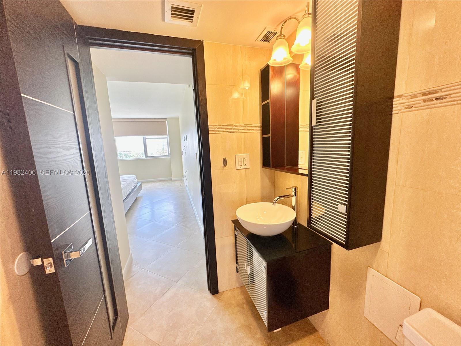 A high-rise residential building with balconies overlooks a rectangular swimming pool on a paved patio — 3180 S Ocean Dr # 401, Hallandale Beach FL 33009, HALLANDALE BEACH, FL