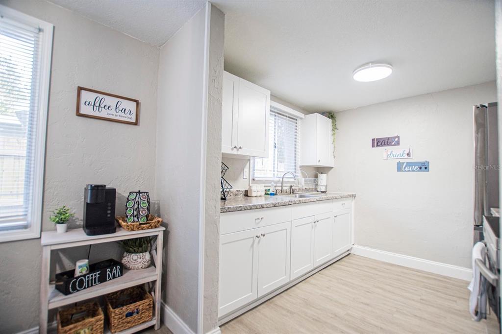 A kitchen features white cabinets, laminate countertops, and a separate coffee bar station — 4615 LORDS AVENUE, SARASOTA, FL