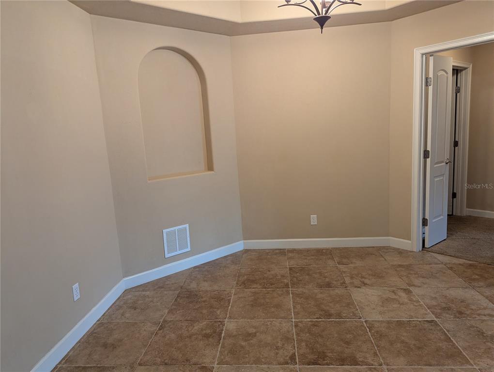 A dining area features tan walls, a recessed arched niche, and light brown tile flooring — 424 LUNA BELLA LANE UNIT 424, NEW SMYRNA BEACH, FL