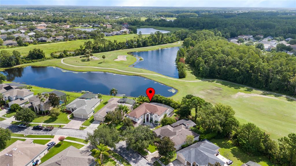An aerial view shows a residential house with a pool cage overlooking a golf course — 2072 STONE CROSS CIRCLE, ORLANDO, FL