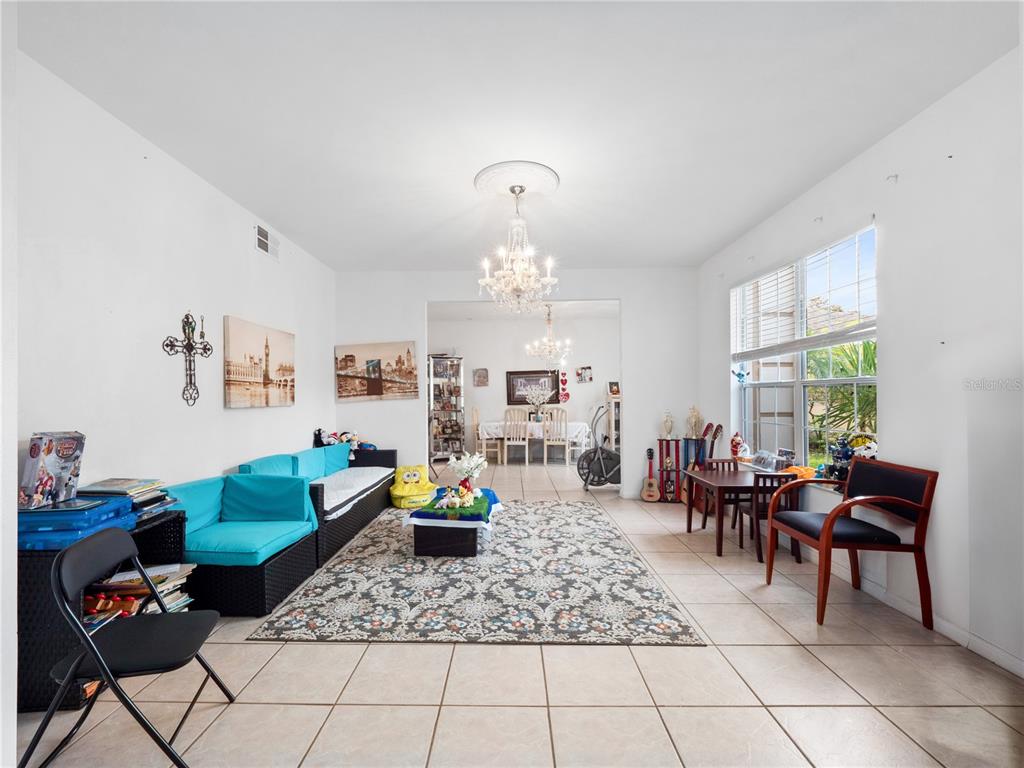 A living room with tile floors, a turquoise sofa, a patterned rug, and a chandelier — 2072 STONE CROSS CIRCLE, ORLANDO, FL