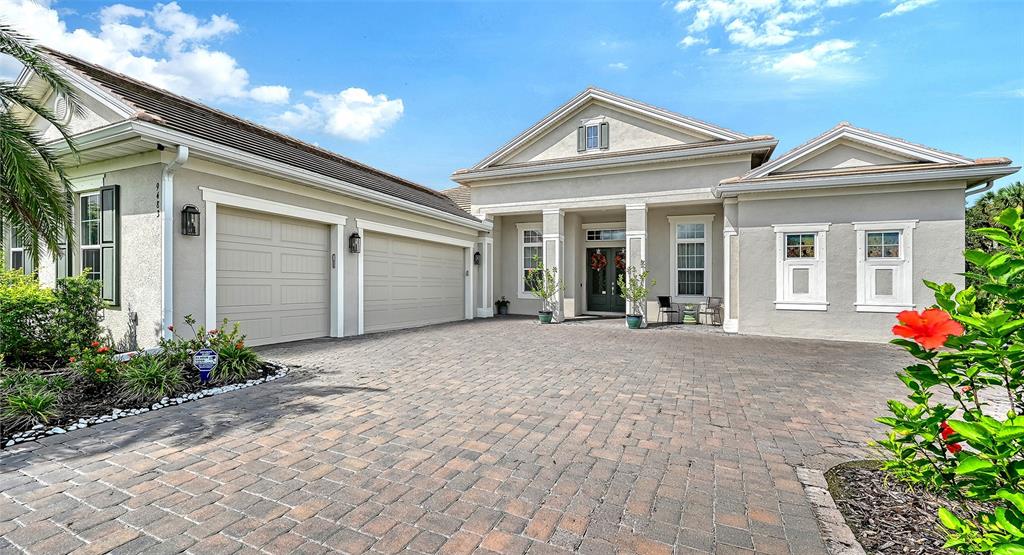 A single-story house with a paved driveway, a three-car garage, and a front entrance — 9483 TEQUILA SUNRISE DRIVE, SARASOTA, FL