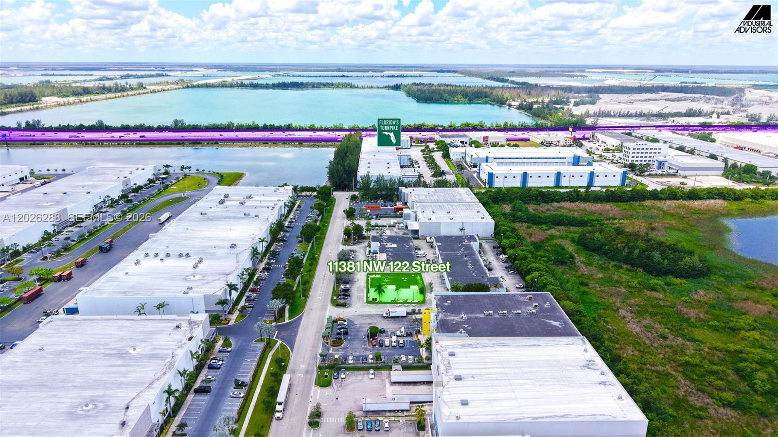 An aerial view shows industrial warehouse buildings and parking lots surrounded by water and vegetation — 11381 NW 122nd St # 10, Medley FL 33178, MEDLEY, FL