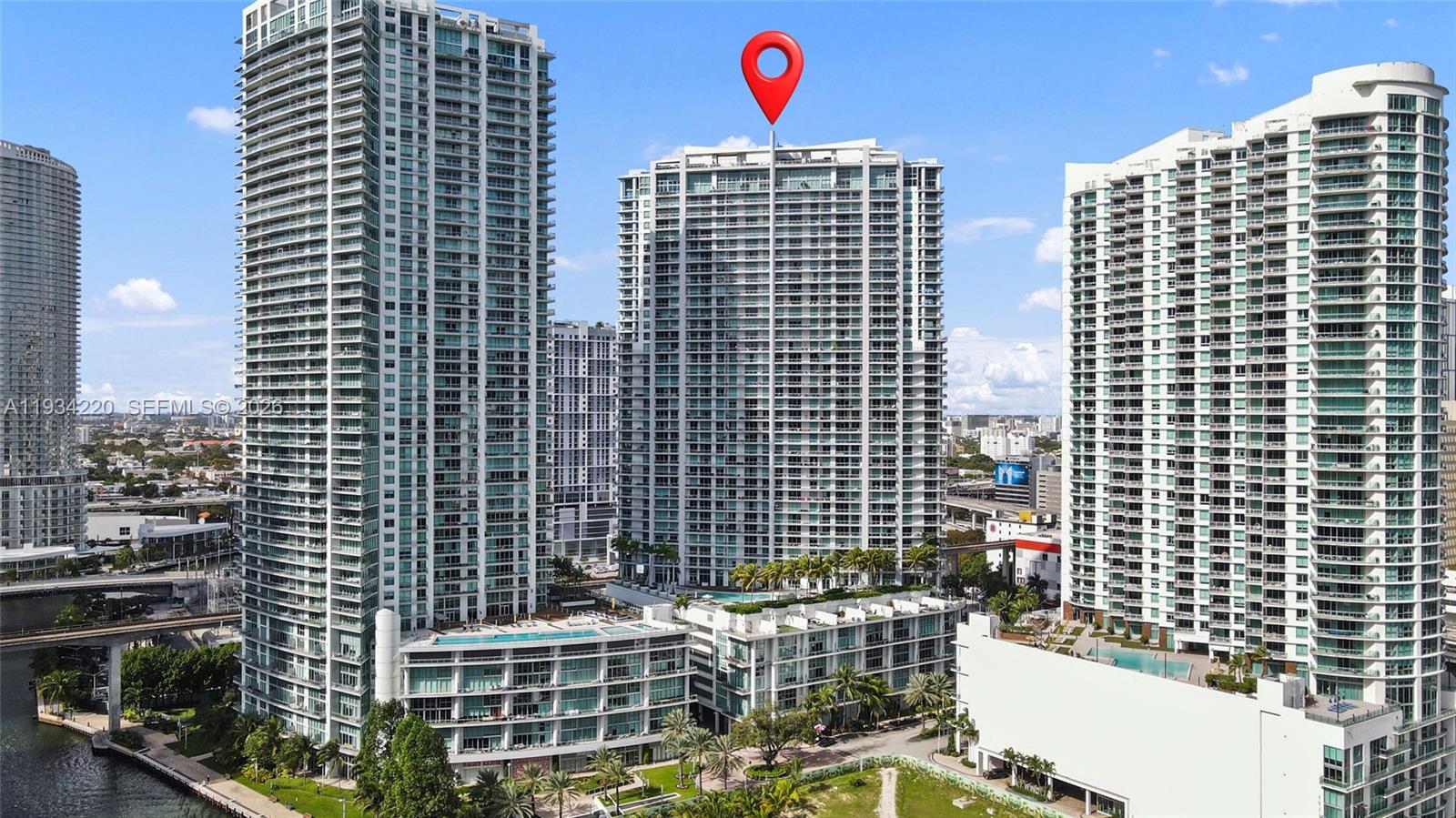 An aerial view shows three tall residential skyscrapers in an urban setting near a river — 90 SW 3rd St # 2109, Miami FL 33130, MIAMI, FL