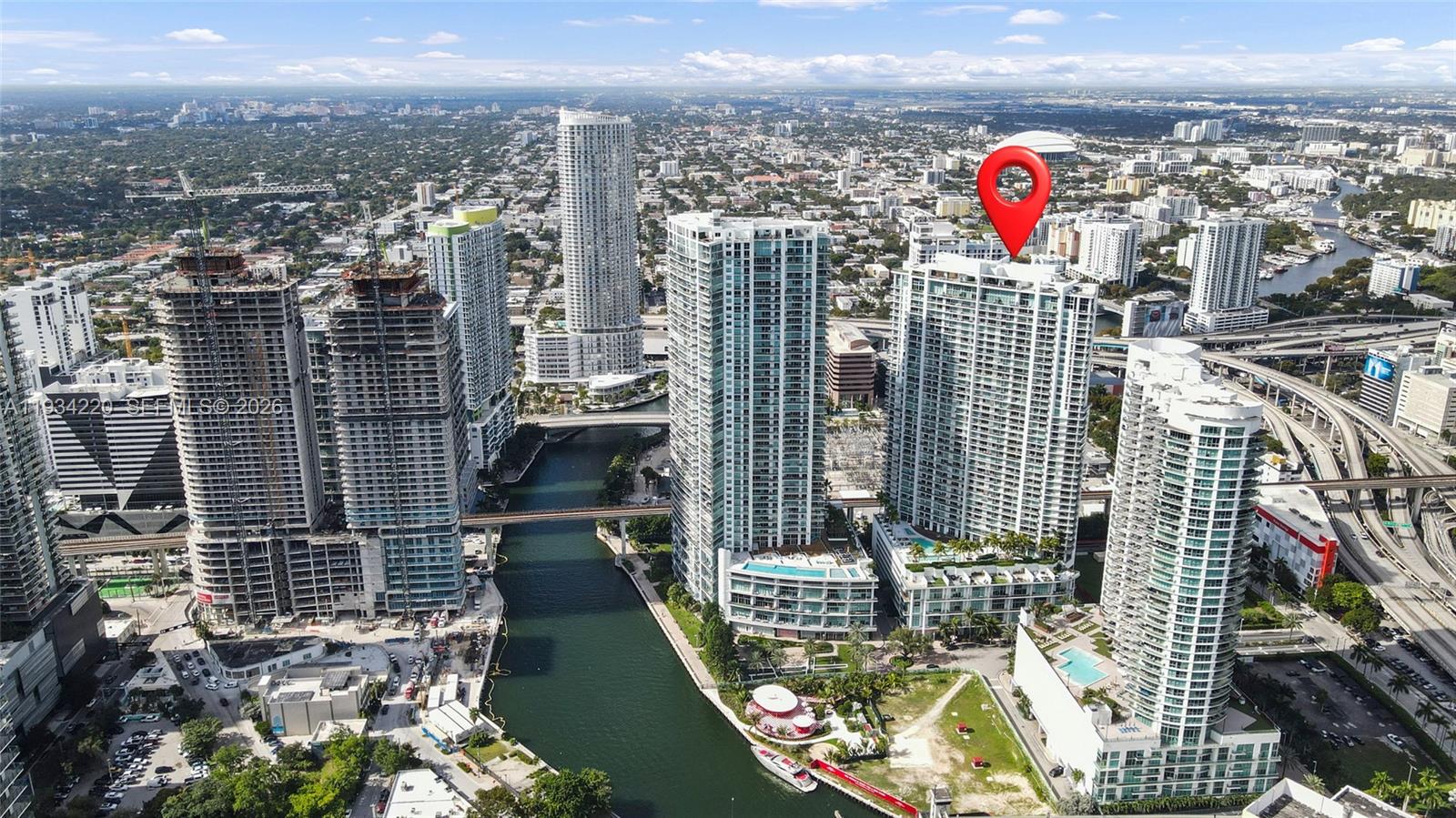An aerial view shows several high-rise residential buildings along a river in a city — 90 SW 3rd St # 2109, Miami FL 33130, MIAMI, FL