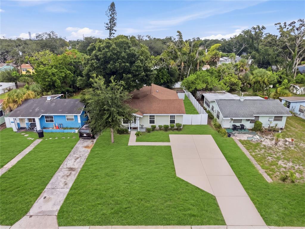 An aerial view shows a light green house with a brown roof between two neighbors — 1542 28TH STREET S, ST PETERSBURG, FL