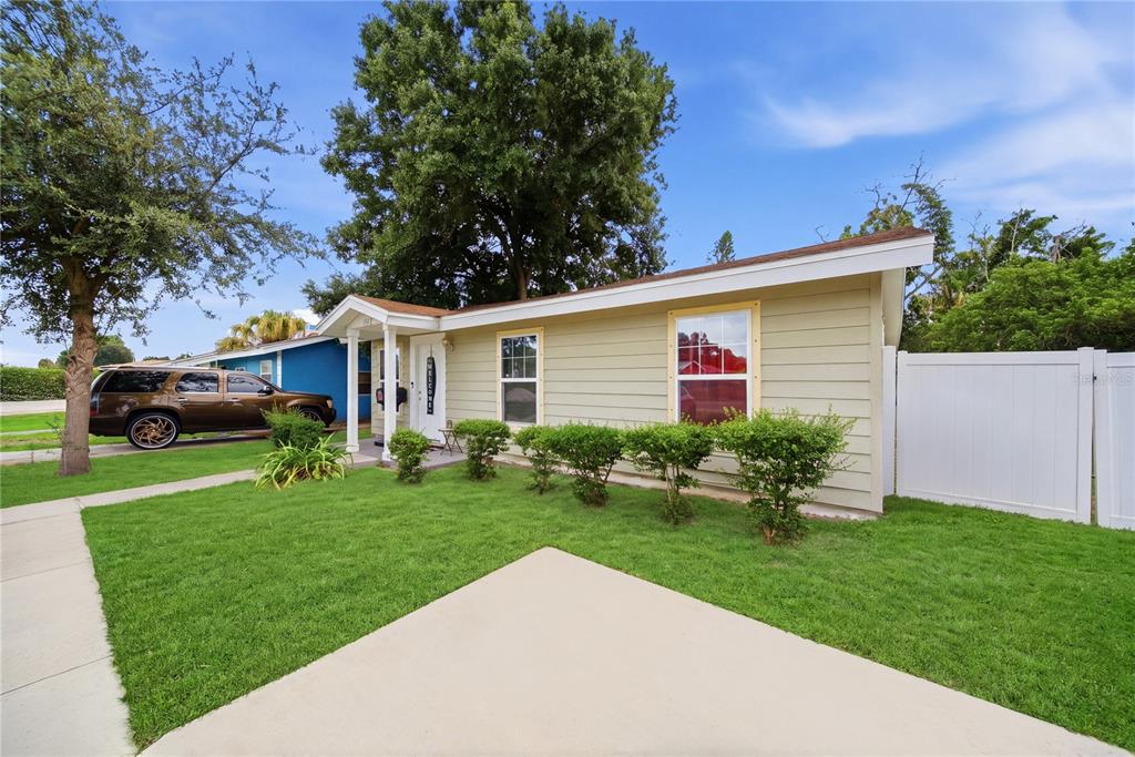 A single-story house with light-colored siding, a small front porch, and a white vinyl fence — 1542 28TH STREET S, ST PETERSBURG, FL