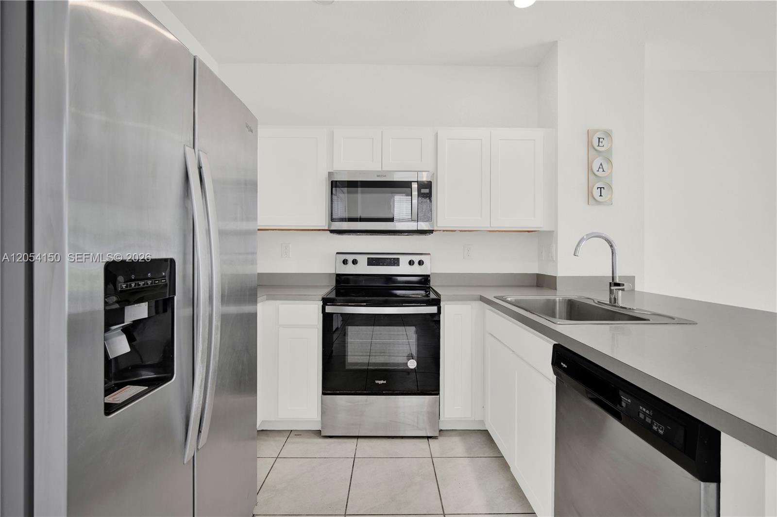 A kitchen features white cabinets, stainless steel appliances, gray countertops, and light tile flooring — 1161 SW 8th Ave, Florida City FL 33034, FLORIDA CITY, FL