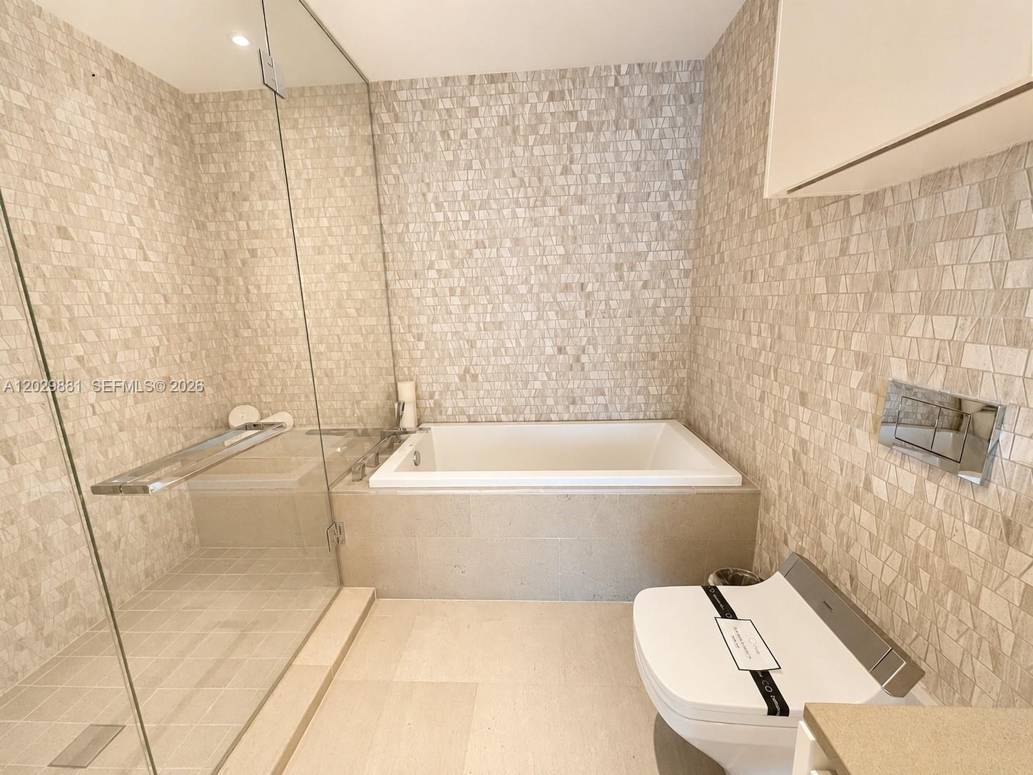 A bathroom features a glass-enclosed shower, a built-in bathtub, and a wall-mounted toilet — 88 SW 7 # 3506, Miami FL 33130, MIAMI, FL