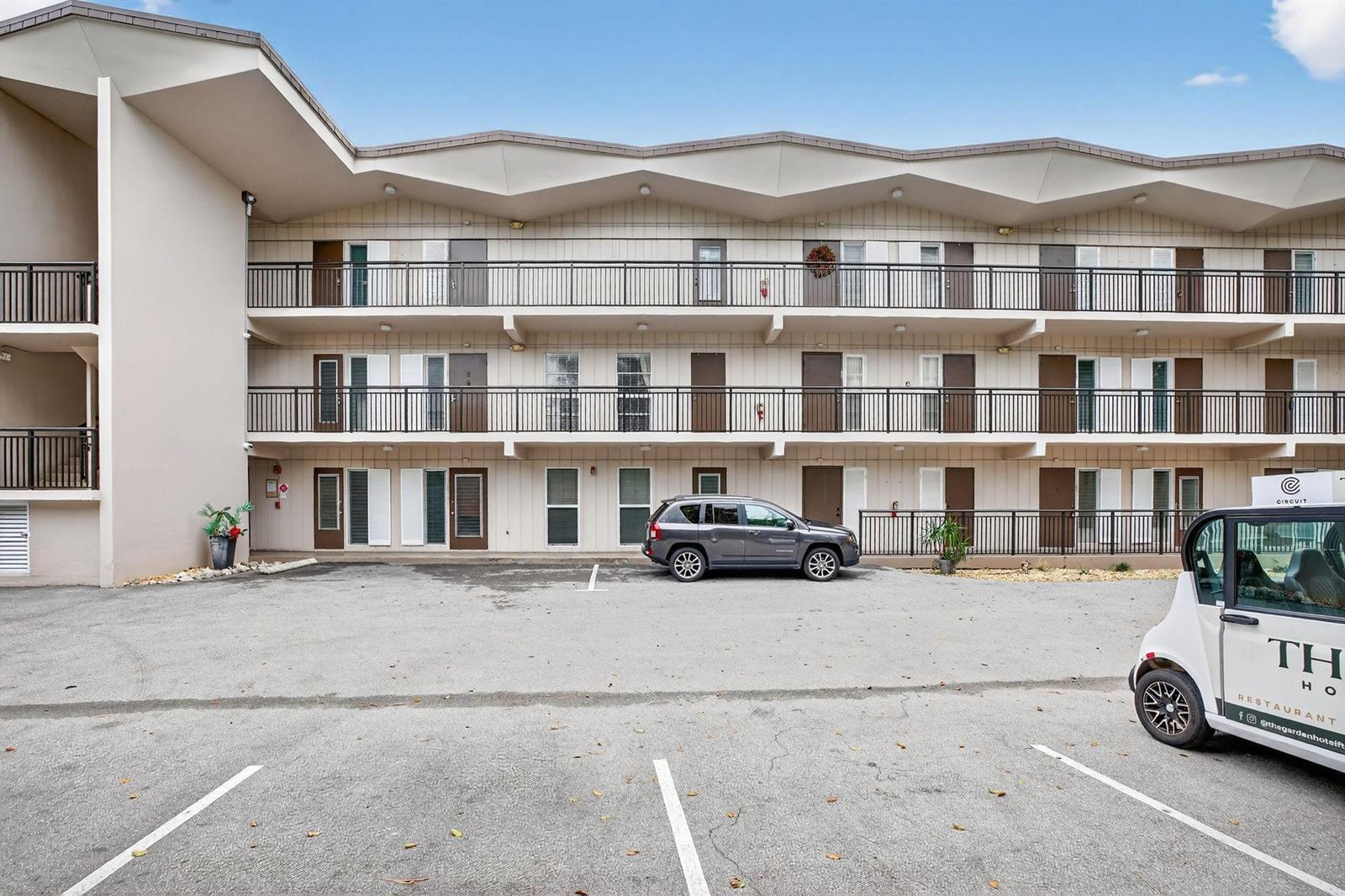 A three-story motel exterior features a zig-zag roofline, exterior walkways with railings, and a parking lot — 1967 S Ocean Boulevard # 103, Pompano Beach FL 33062, POMPANO BEACH, FL