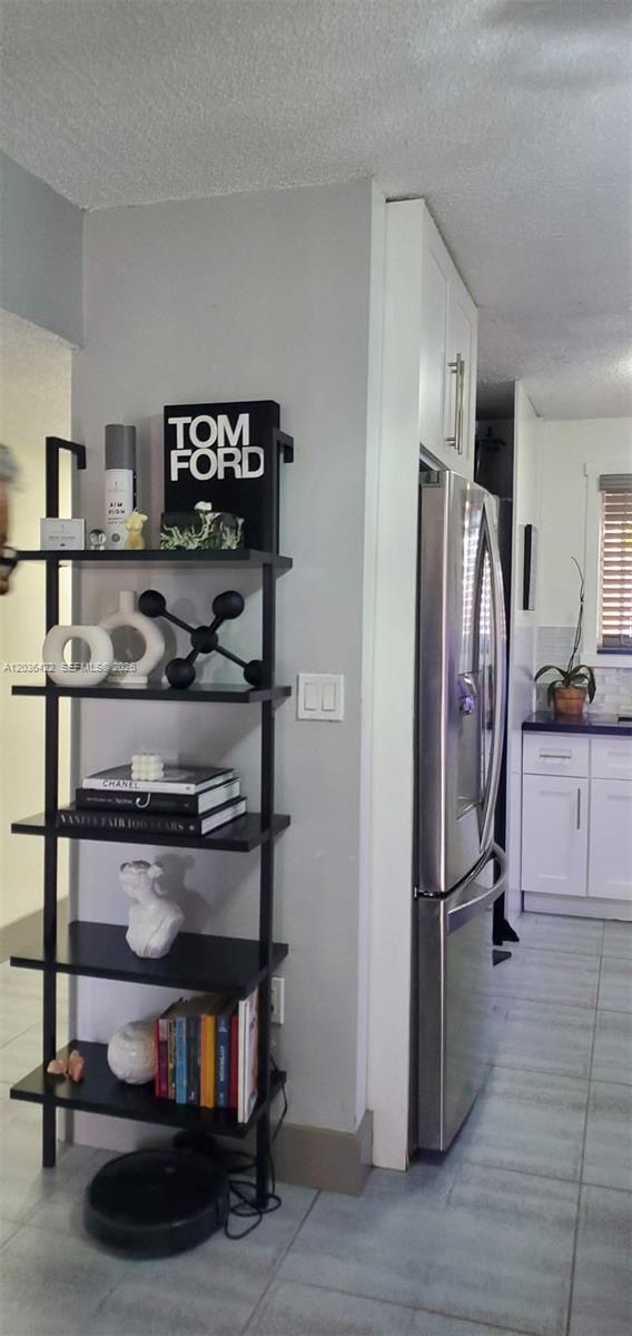 A black ladder shelf stands against a grey wall next to a stainless steel refrigerator — 7835 W 30th Ct # 104, Hialeah FL 33018, HIALEAH, FL