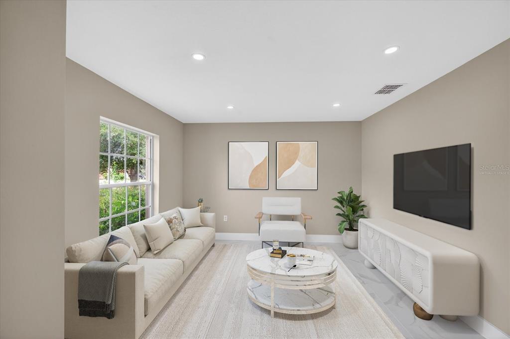 This is a virtually staged living room with a sofa, armchair, coffee table, and television — 12783 LINDEN DRIVE, SPRING HILL, FL