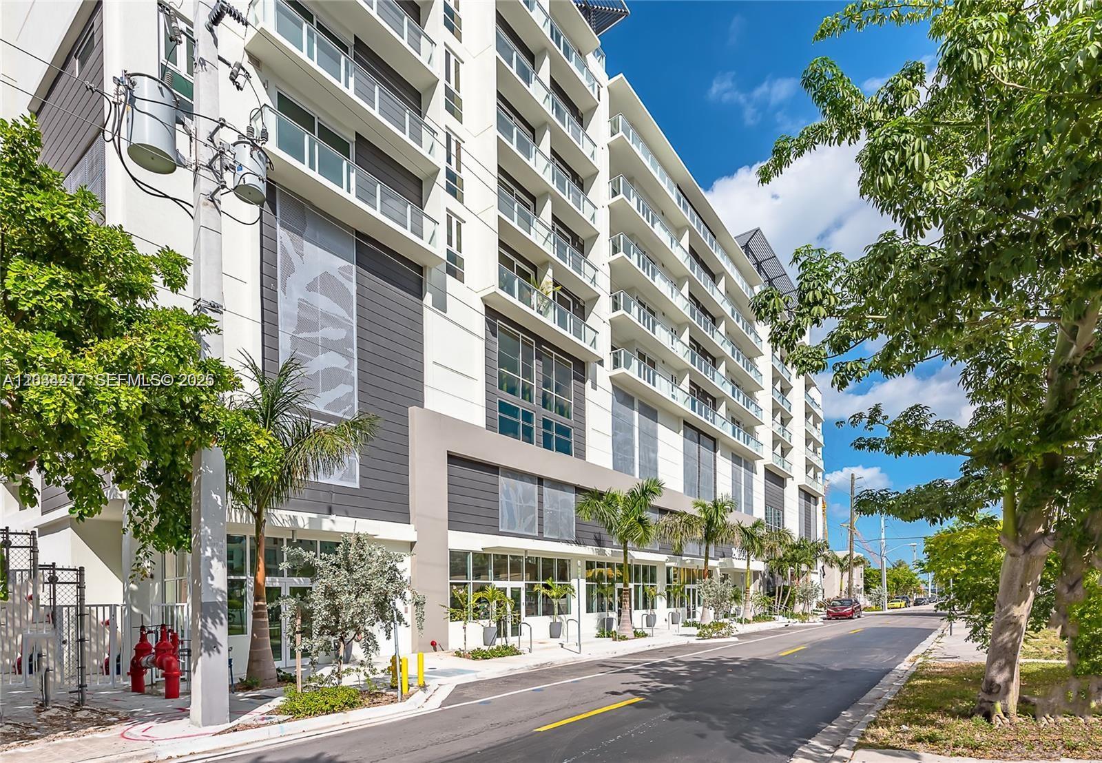 The exterior of a modern multi-story apartment building features glass balconies and street-level storefronts — 321 NE 26th St # 512, Miami FL 33137, MIAMI, FL