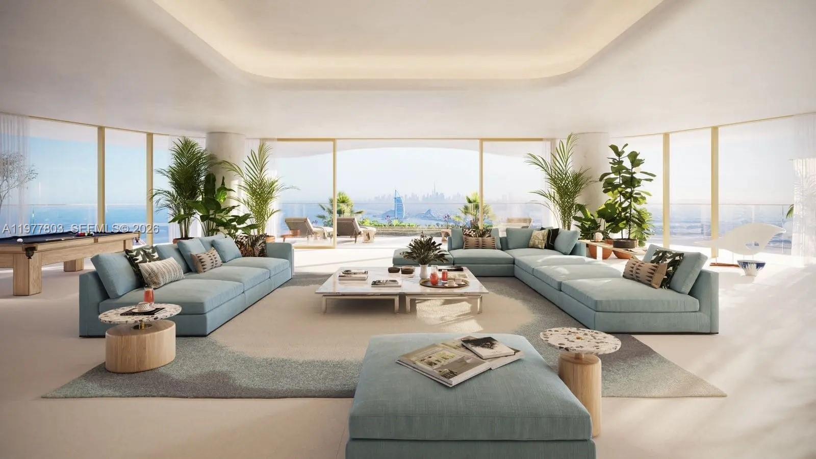 This rendering shows a spacious living room with light blue sofas, a central coffee table, and floor-to-ceiling windows overlooking the ocean — PJCRC17 Ittihad Rd # 0, Dubai, FL