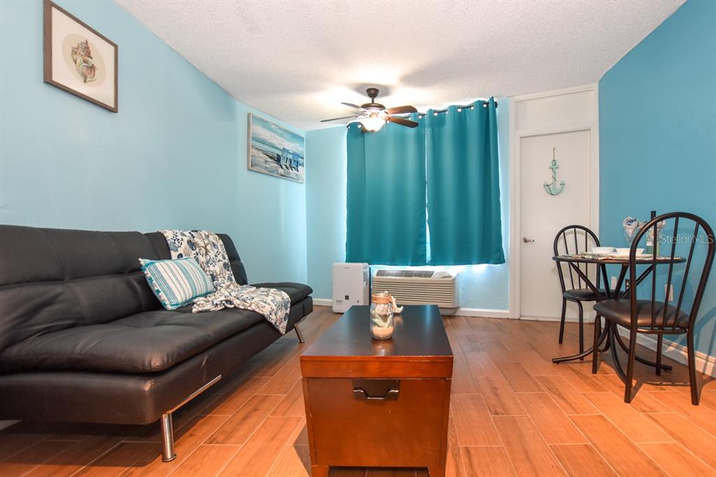 A living room features a black sofa, a wooden coffee table, and a small dining set — 313 S. ATLANTIC AVE UNIT 526, DAYTONA BEACH, FL