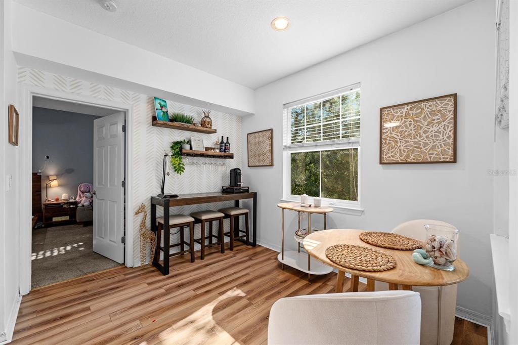 A dining area features wood-look flooring, a bar table with stools, and a round table — 2010 E PALM AVENUE UNIT 14317, TAMPA, FL