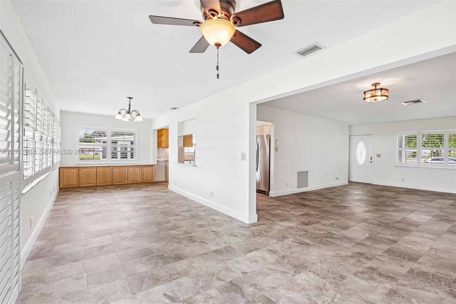 An open-concept living and dining area features tile flooring, white walls, and a ceiling fan — 8855 NW 10th Pl, Plantation FL 33322, PLANTATION, FL