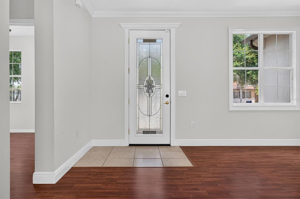 An entryway features a white front door with decorative glass, tile flooring, and wood floors — 3922 CEDAR HAMMOCK TRAIL, ST CLOUD, FL