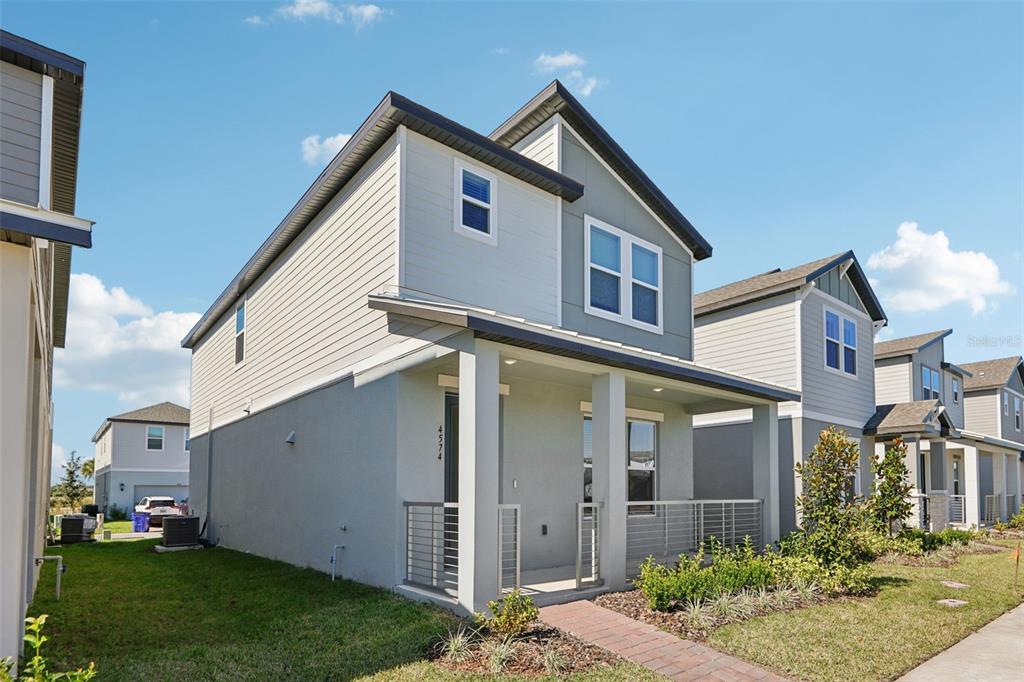 A two-story house with light gray siding, a front porch, and a brick walkway — 4574 HOMESTEAD TRAIL, ST CLOUD, FL