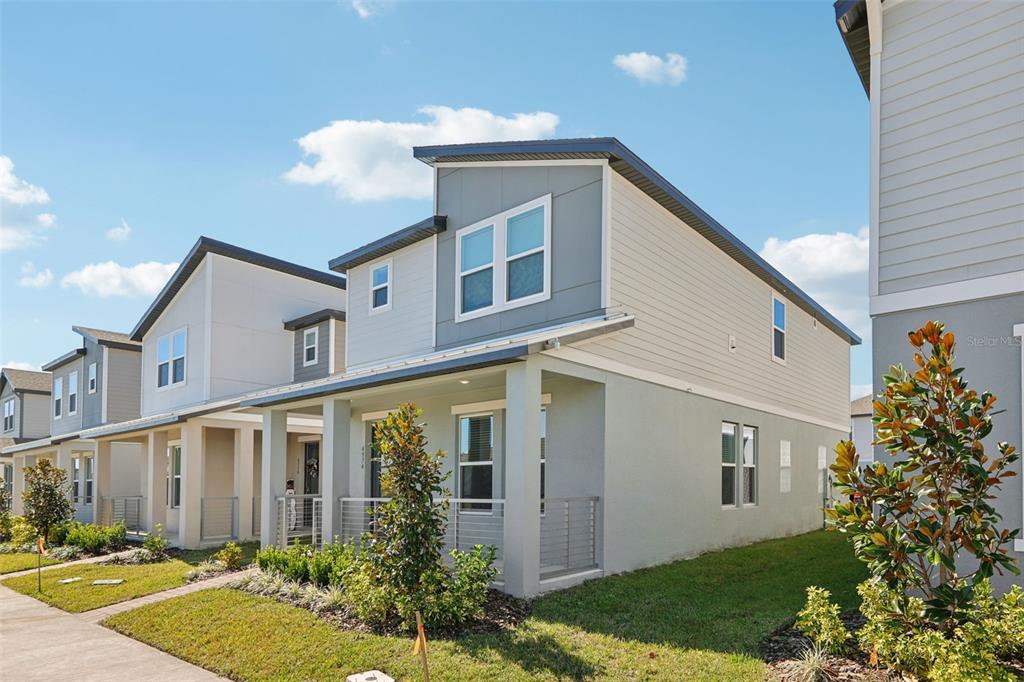 A row of modern two-story townhomes with light-colored siding and covered front porches — 4574 HOMESTEAD TRAIL, ST CLOUD, FL