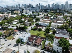 An aerial view shows a neighborhood with low-rise buildings and houses near a city skyline — 315 SW 10th Ave, Miami FL 33130, MIAMI, FL