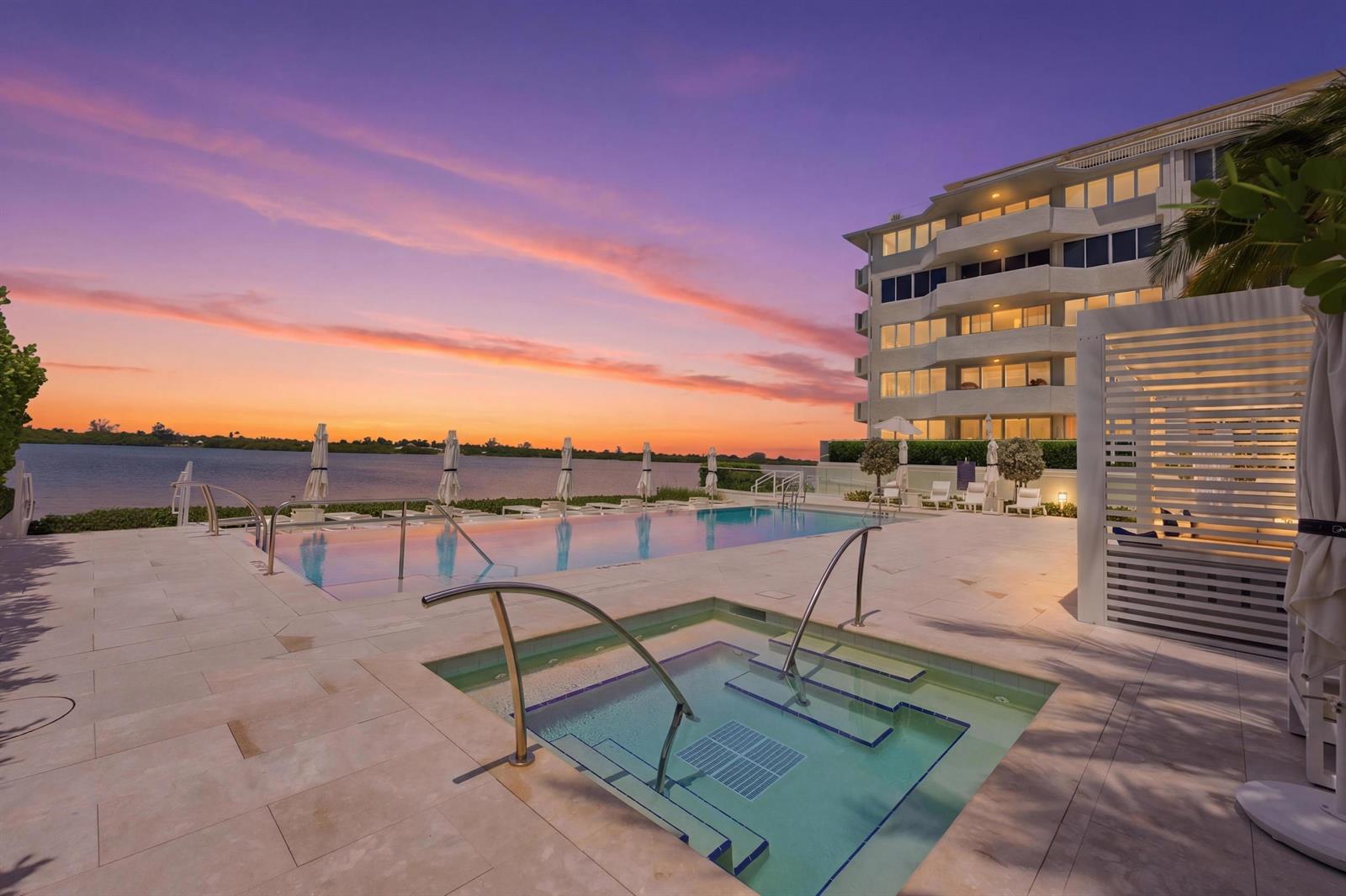 An outdoor swimming pool and hot tub overlook a body of water at sunset — 2773 S Ocean Boulevard # 5140, Palm Beach FL 33480, PALM BEACH, FL